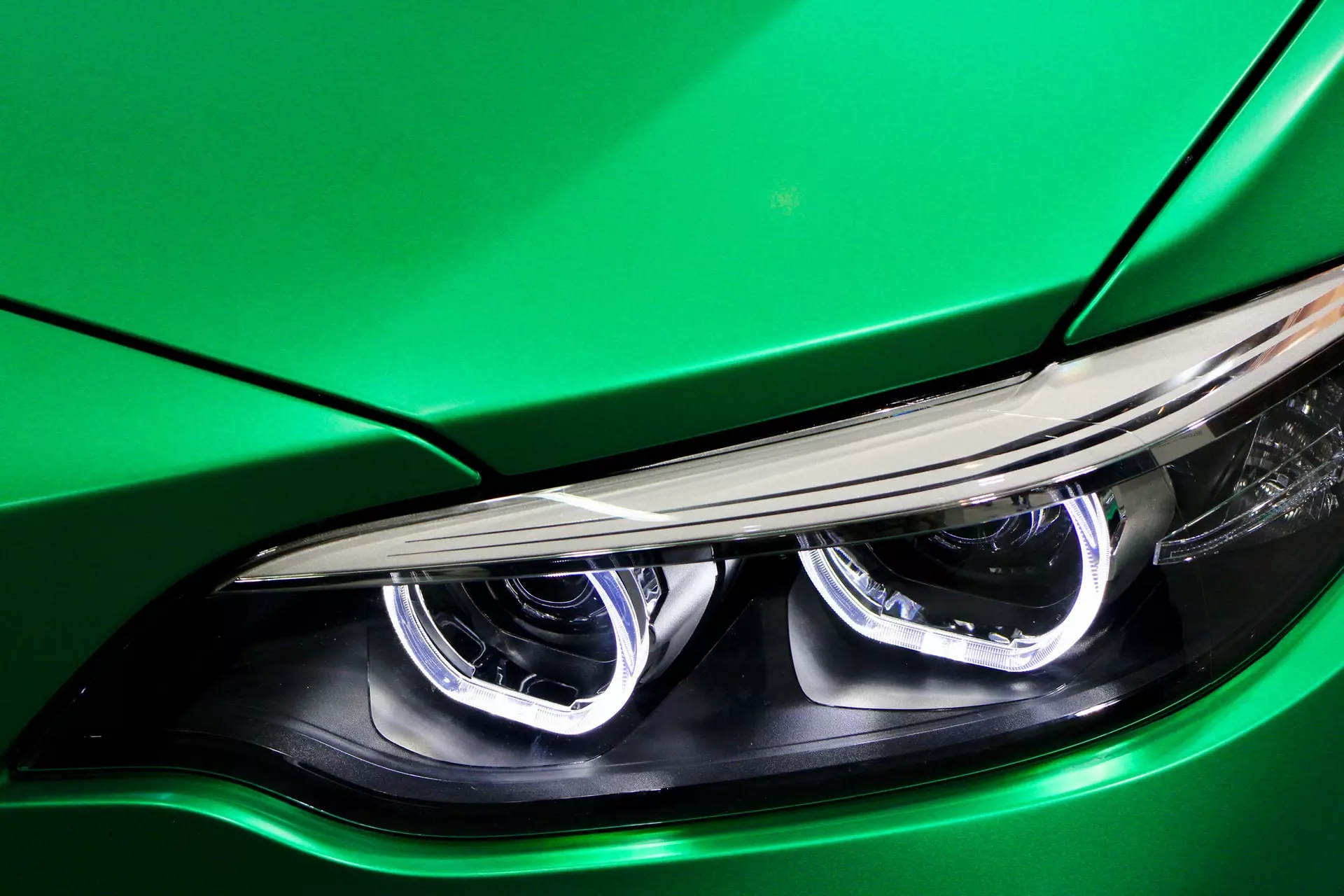 Передняя фара зеленого автомобиля