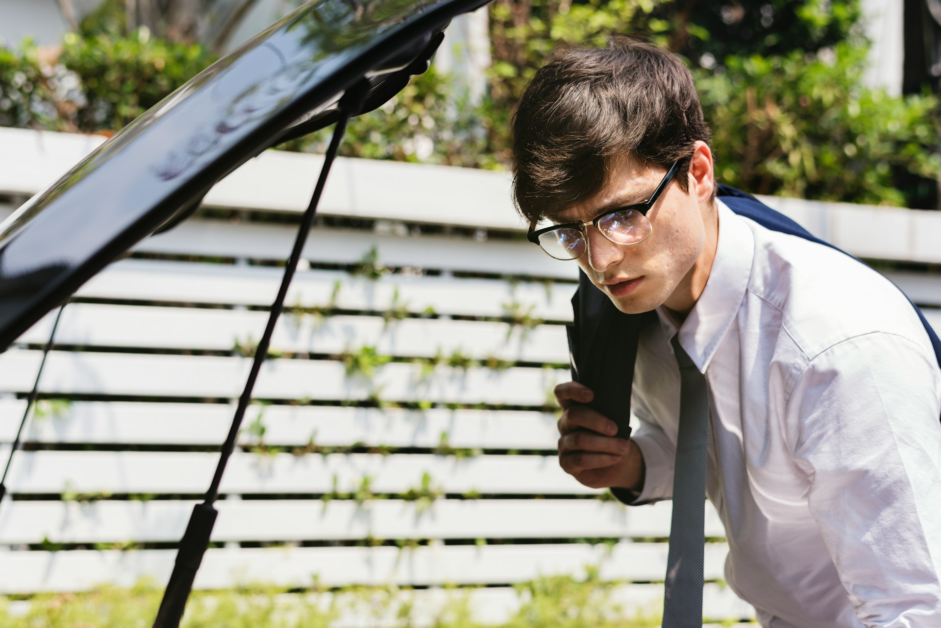 a student checks the condition of a car on the road