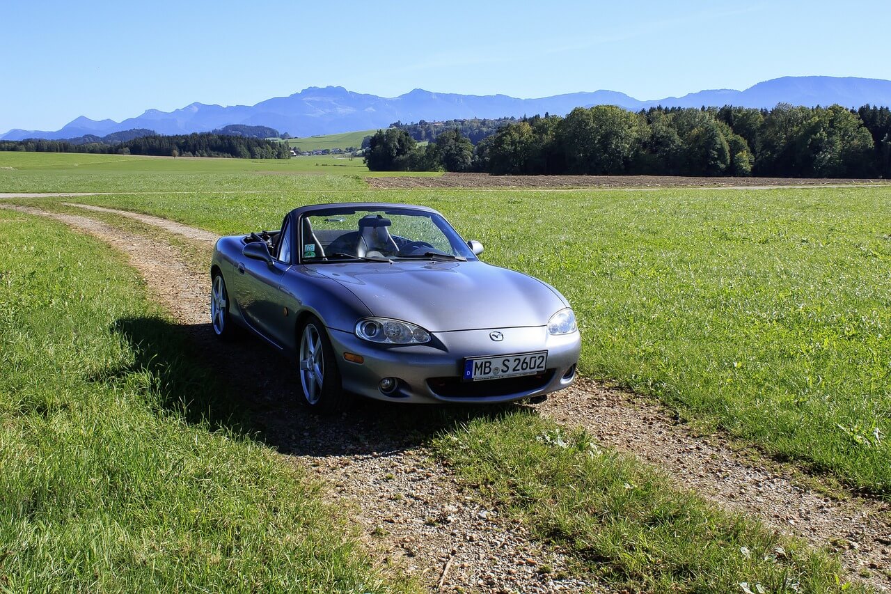 a Mazda convertible near the forest