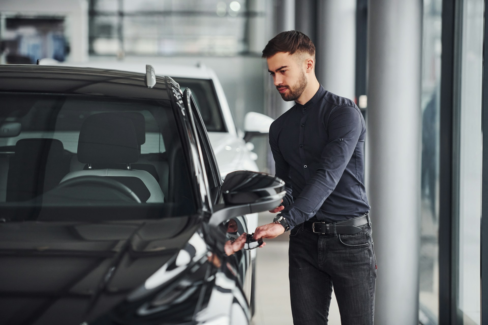 man opening doors of his new car