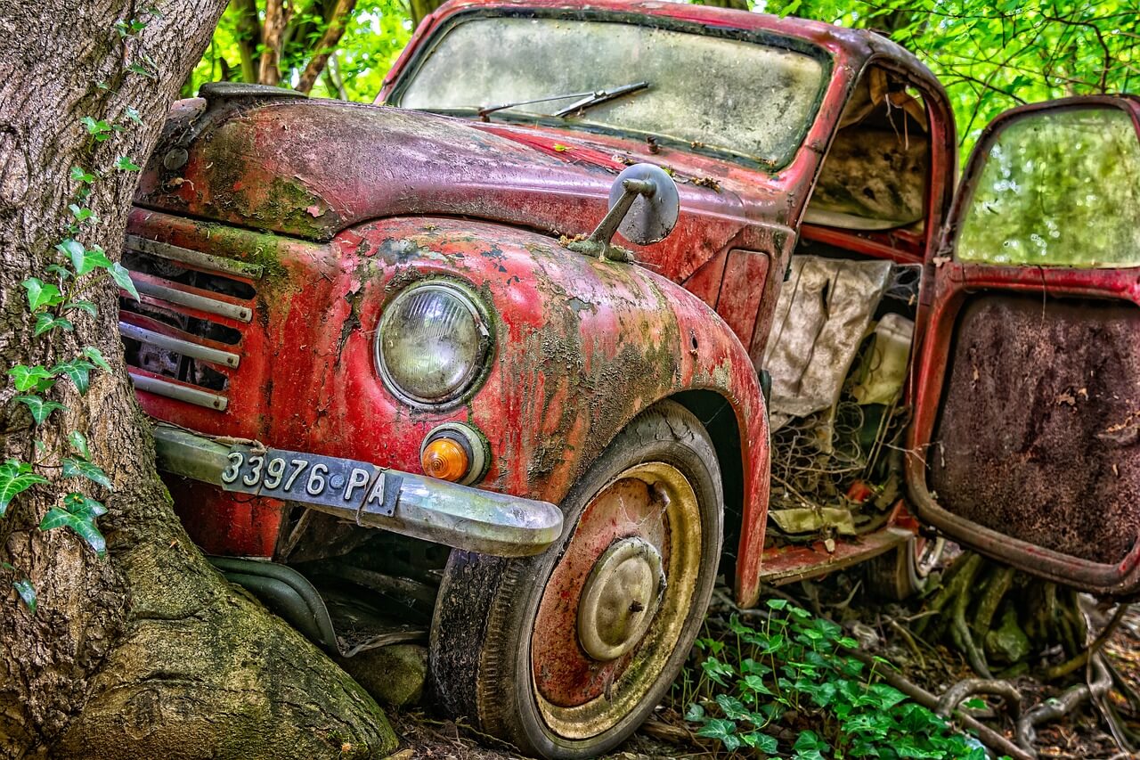 a damaged car in the forest